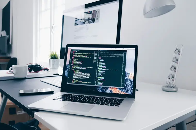 Code on a laptop screen in a bright workspace